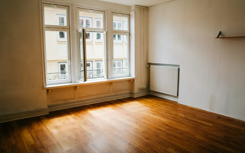 Empty apartment with clean floors and open kitchen cabinets